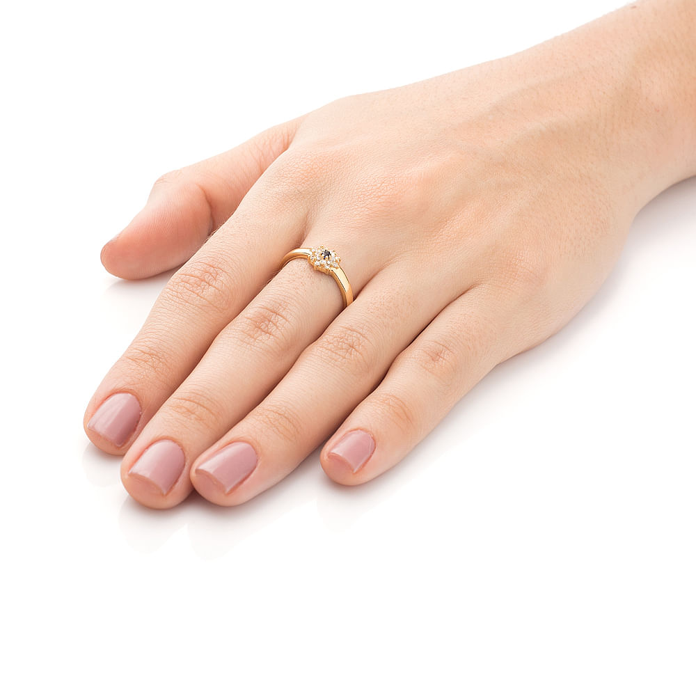 Mão de mulher com anel de formatura Administração feminino de safira e diamantes em still.