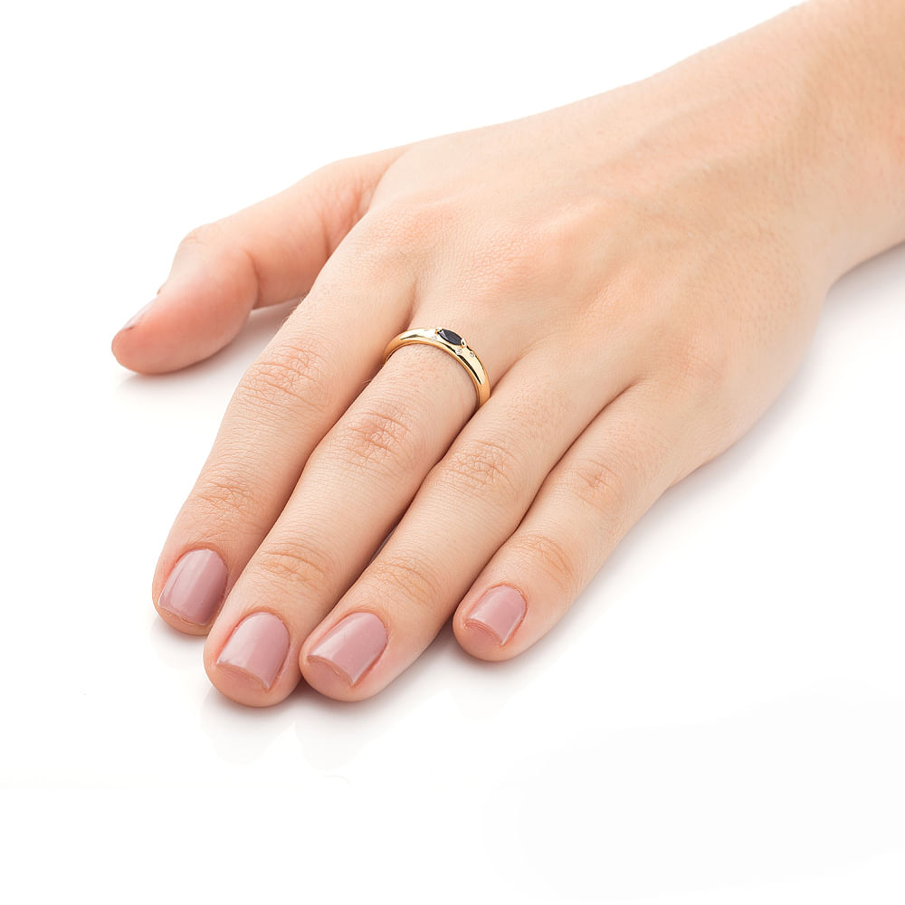 Mão de mulher com anel de formatura Pedagogia feminino com safira e diamantes em still